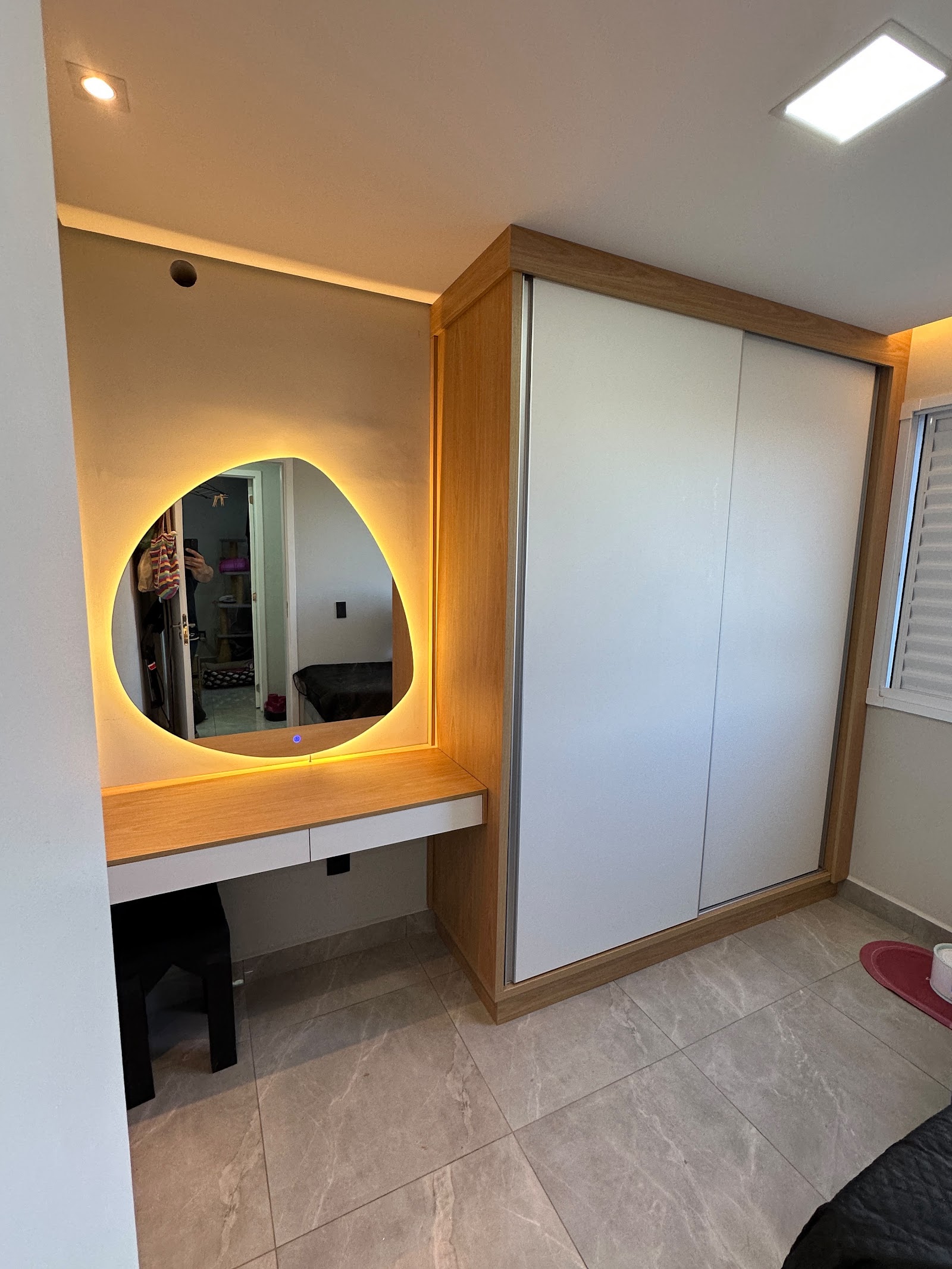 Quarto planejado pela G&S com guarda-roupa, madeira e iluminação quente na penteadeira